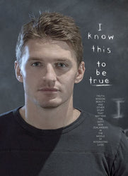 Man wearing a black t-shirt with text on a chalkboard background
